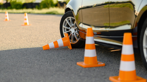 Car and downed traffic cone, lesson in driving school concept, nobody. Teaching to drive vehicle theme. Driver's license education